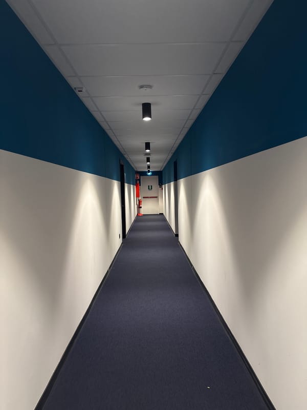 Young man takes playful distorted selfie in Italian corridor