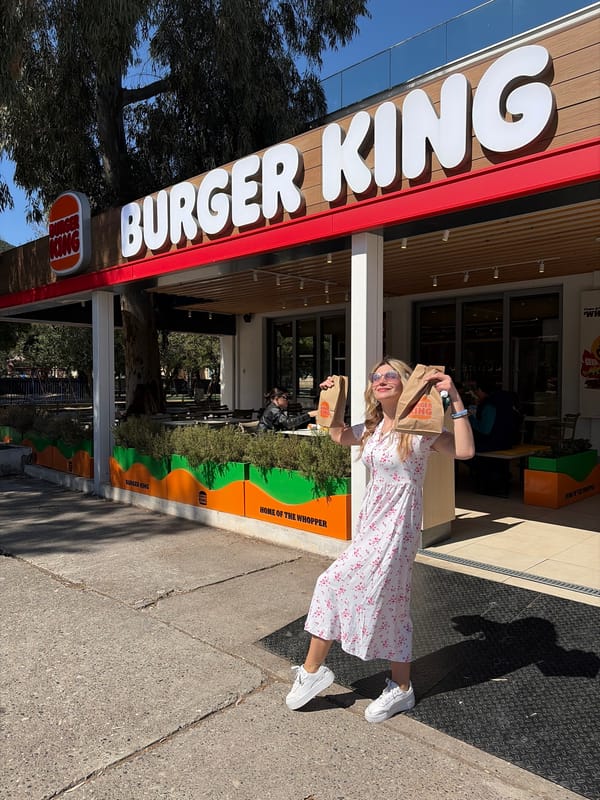 Woman walks dog while carrying leafy branch in Budva