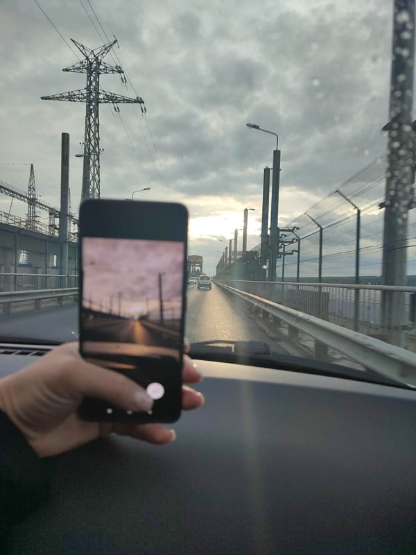 Driver documents overcast journey across water on rainy afternoon