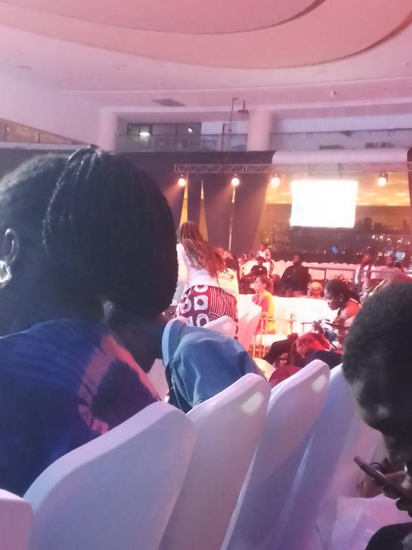 Indoor conference gathering draws seated audience to illuminated stage