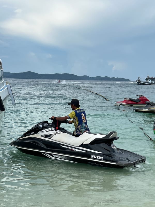 Crowded beach morning in Phru Nai with boats, jet skis, and water activity