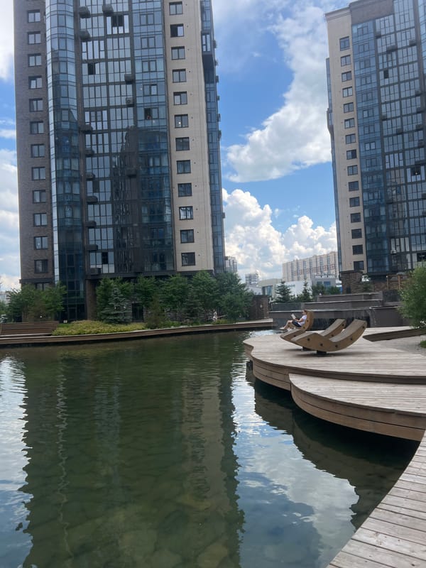 Krasnoyarsk waterfront park with cascading water feature and modern towers