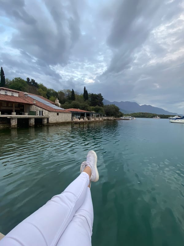 Person dangles feet over water in Montenegro lakeside moment