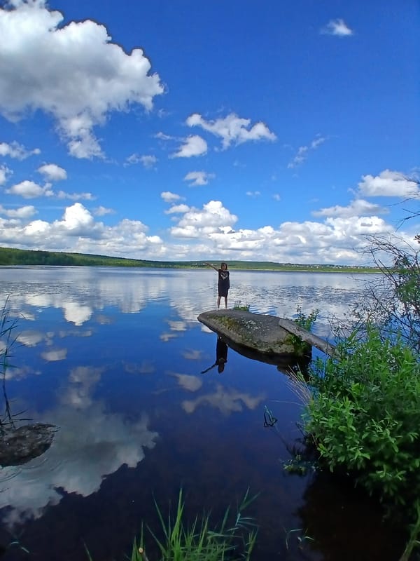 Still lake near Yekaterinburg reflects clear summer sky