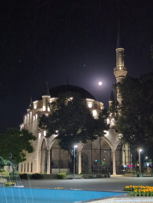 Ibrahim Pasha Mosque lit up under a full moon in Razgrad