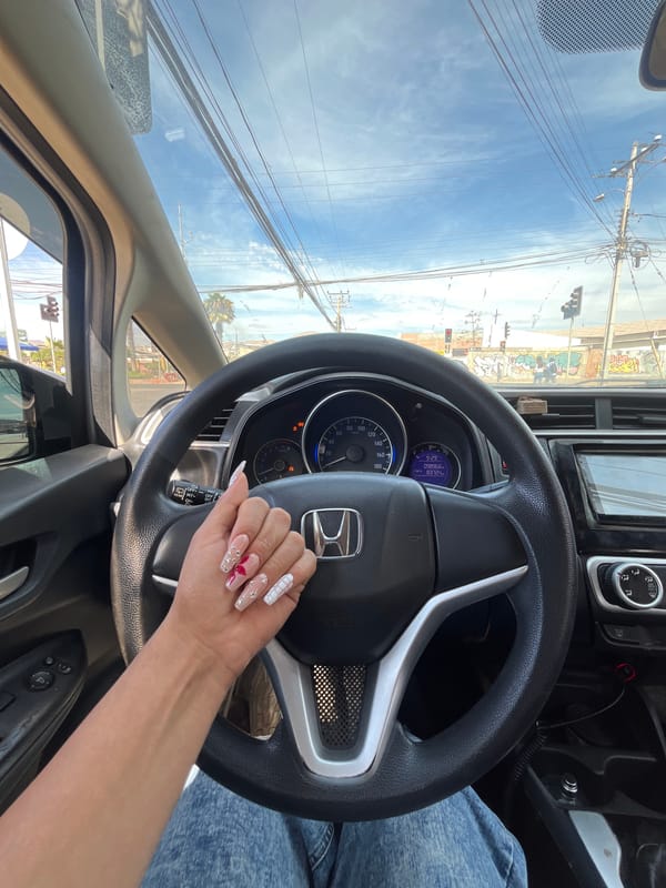 Driver with decorated nails tends to manicure in Honda