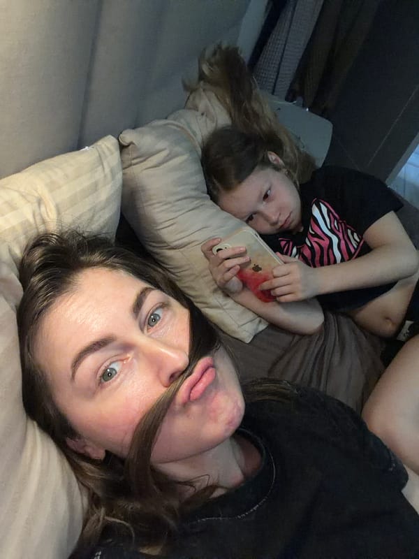 Woman and child rest together on bed in Dubovaya