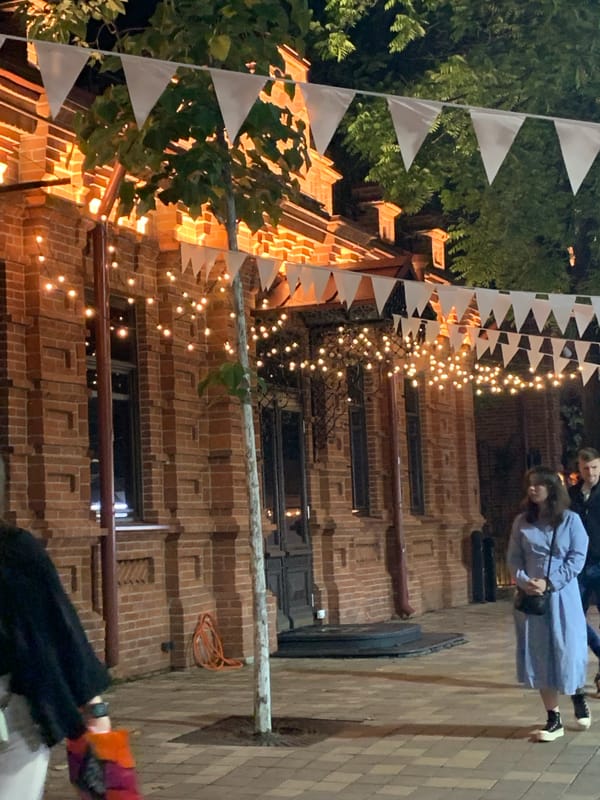 Evening street festival features illuminated fountains and decorated walkways