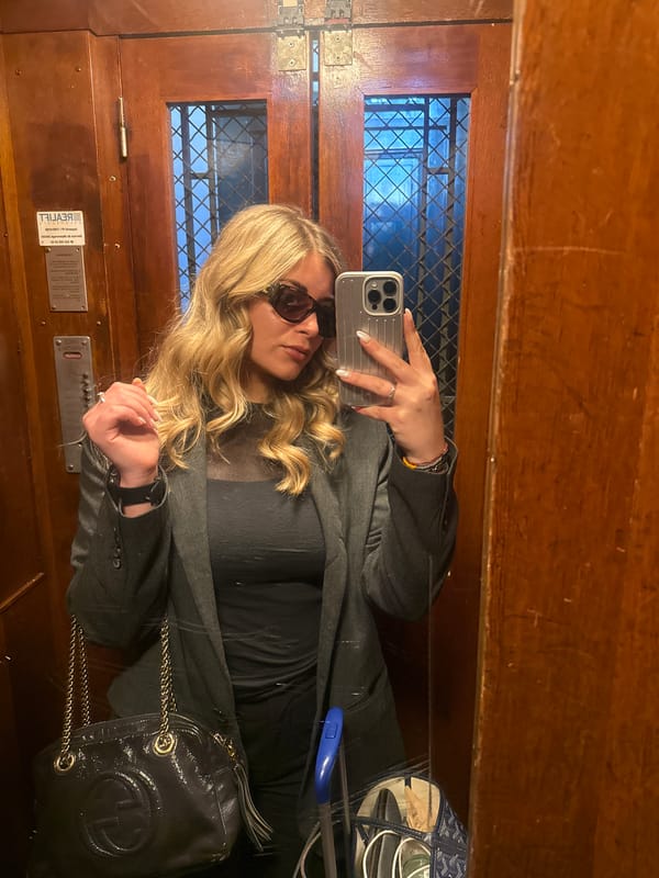 Woman takes selfie, rests on stone surface in Geneva