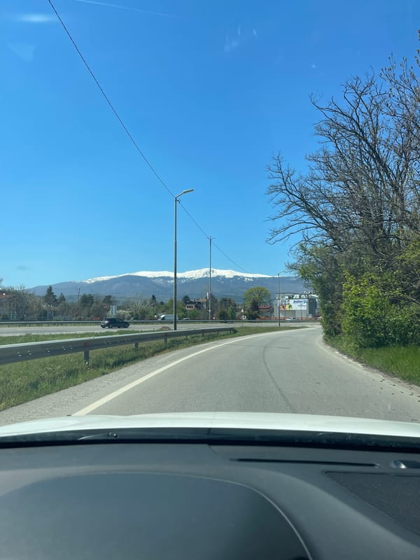 Spring drive through Lozen reveals distant snow-capped mountains
