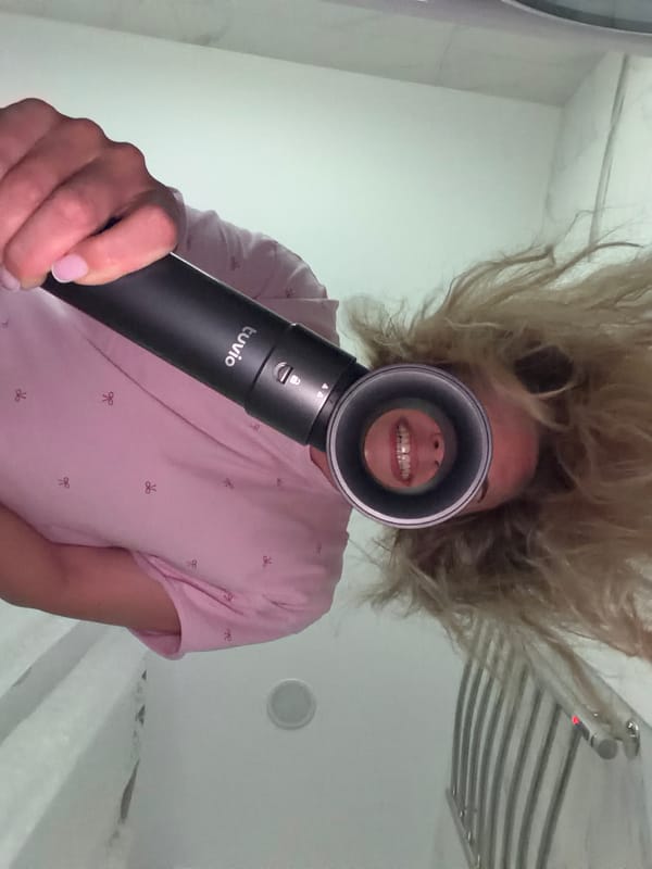 Woman documents hair care routine with flowers in Votkinsk bathroom