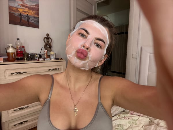 Woman documents skincare routine in bedroom selfie session