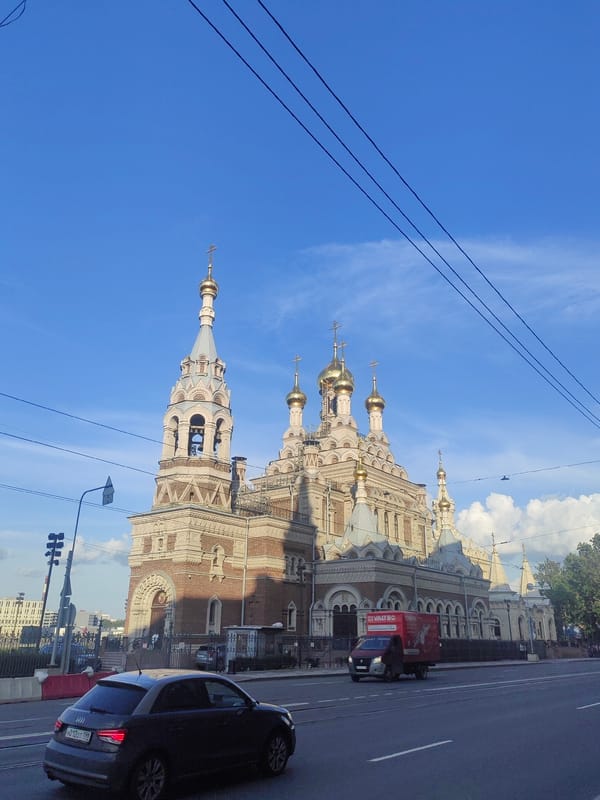 Cyclist passes golden-domed Orthodox church in Saint Petersburg