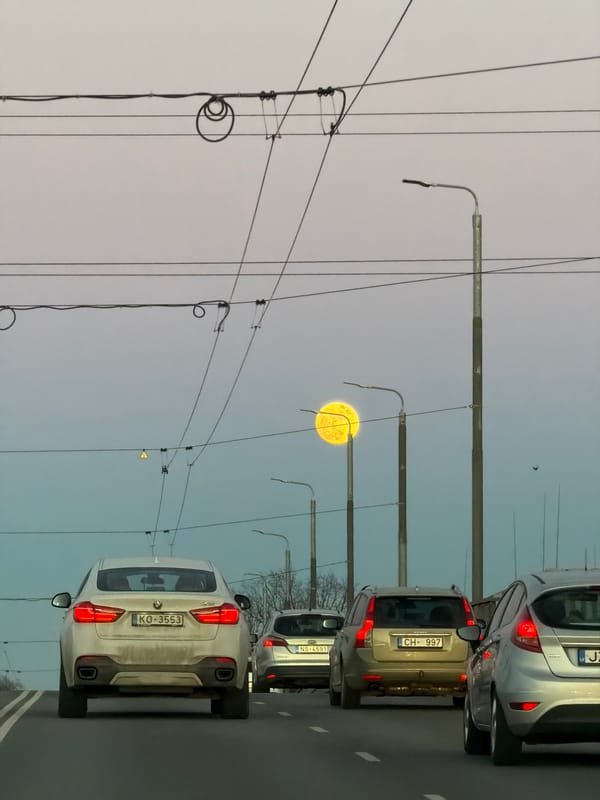 Evening traffic flows through Riga streets at dusk