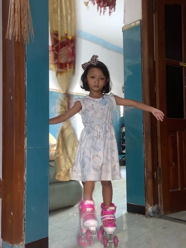 Girl in pink roller skates poses indoors in Gelam