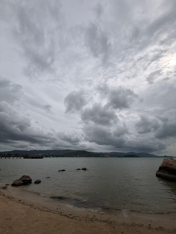 Cloudy morning on Ko Samui's coast, scooters and temple in view