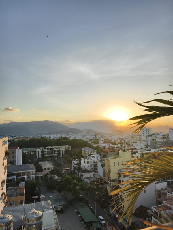 City sunset observed through golden clouds, mountains distant