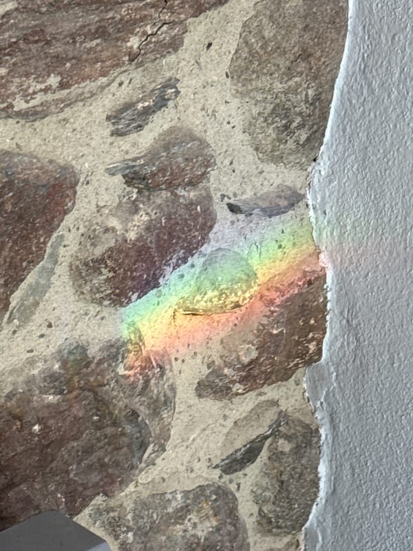 Rainbow reflections and snowy mountains observed in Benasque