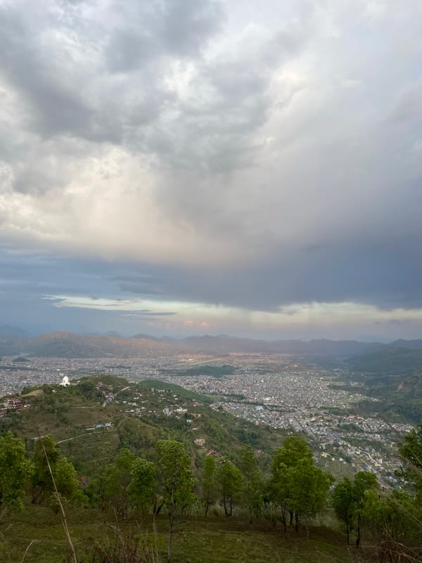 Tourist enjoys scenic overlook of Pokhara during rainbow sighting