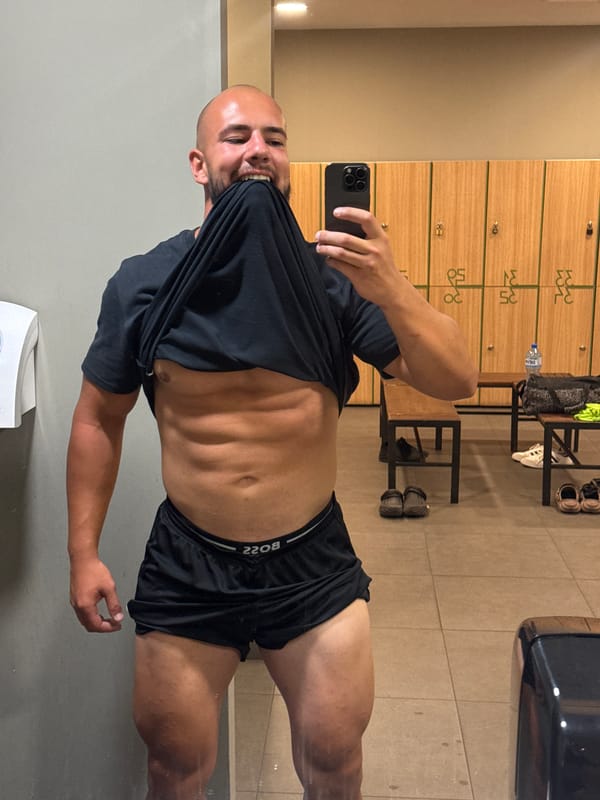 Mirror selfie in a Sofia gym locker room, abs on show.