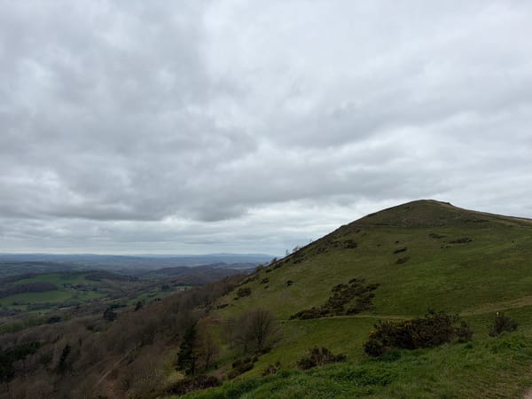Hikers document scenic Malvern Hills landscape views under cloudy skies