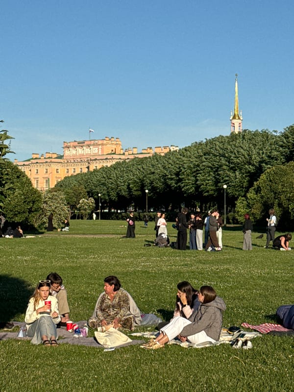 Evening crowds gather across Saint Petersburg's historic landmarks during sunset