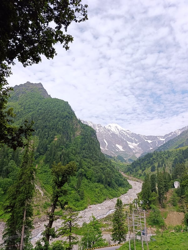 Royal Enfields parked roadside in a Himalayan mountain valley
