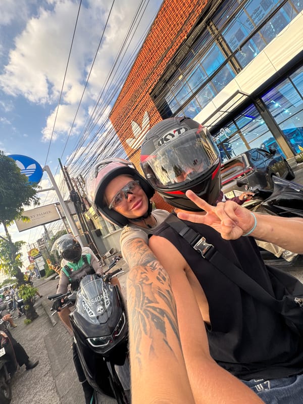 Motorcyclists Make Peace Signs While Riding in Kuta
