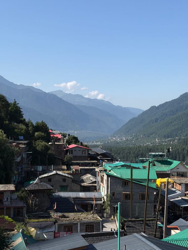 Bahang valley town seen from above, green hills and snowy peaks