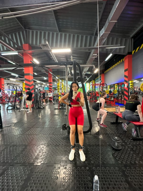 Mirror selfie at a Tyumen gym in red workout gear
