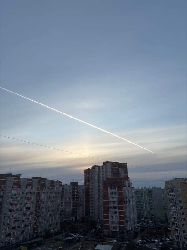 Aircraft contrail observed over apartment buildings in urban area