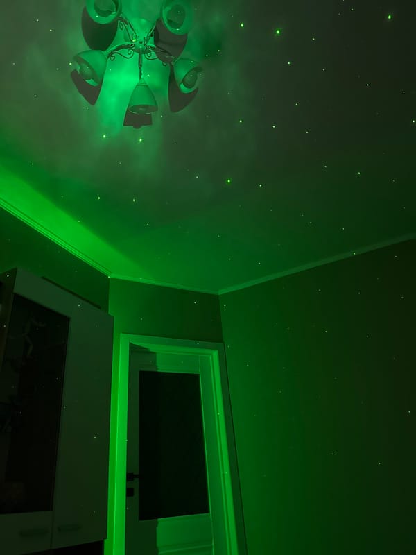 Person watches Russian TV in room with nebula lighting effects