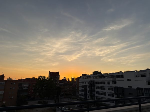 City sunset viewed from a rooftop, orange sky over urban skyline