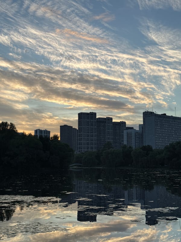 Moscow skyline mirrors across a calm lake at dusk