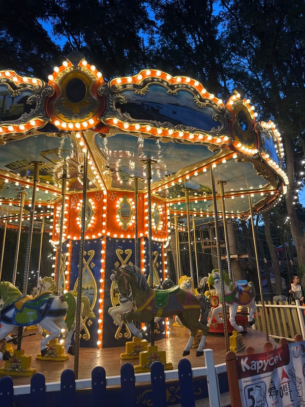 Lit carousel operates at fairground during evening hours