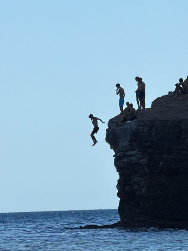 Cliff diving and beach scenes at a rocky Budva coastline