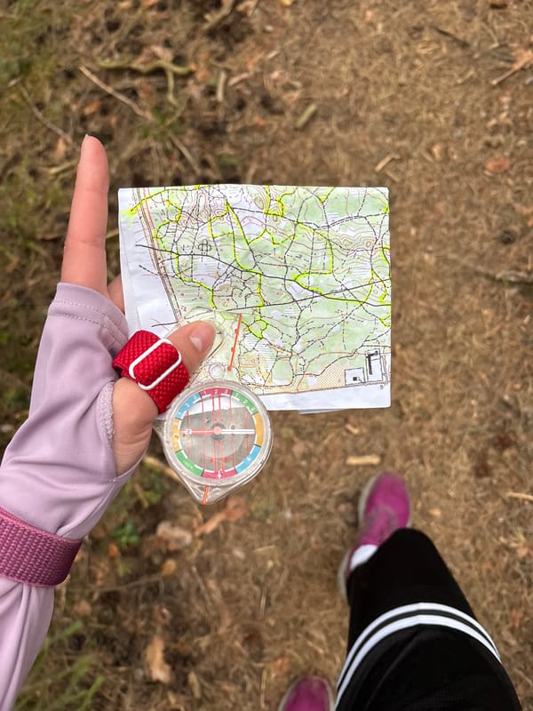 Woman uses map and compass for forest orienteering in Perm