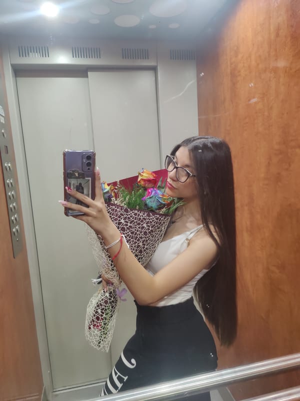 Woman takes elevator selfie with rainbow roses in Plovdiv