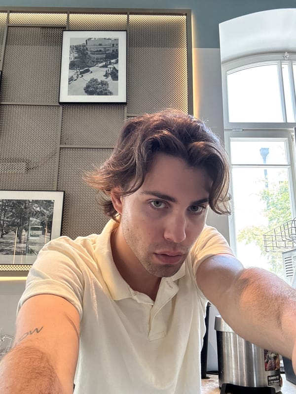 Man takes selfie against decorative wall in Tel Aviv