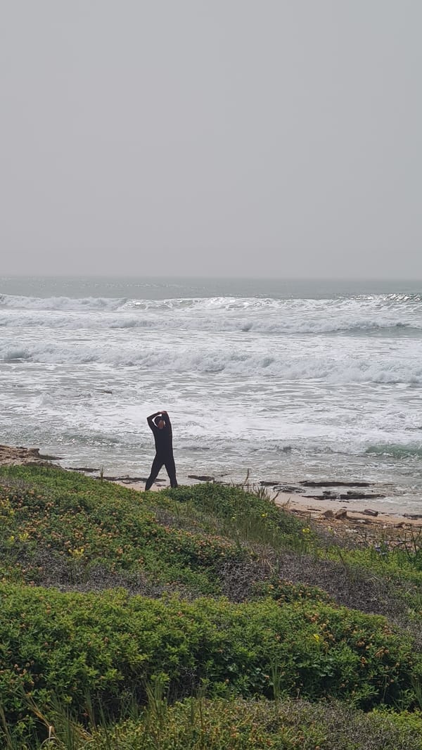 Surfers and beachgoers enjoy overcast Mediterranean coast near Nahariyya