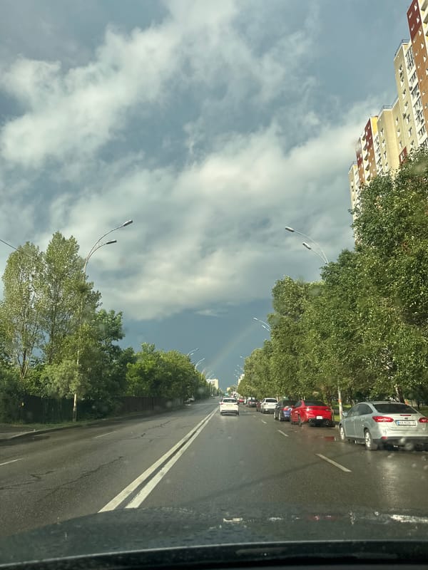 Faint rainbow over a rain-soaked Kyiv street