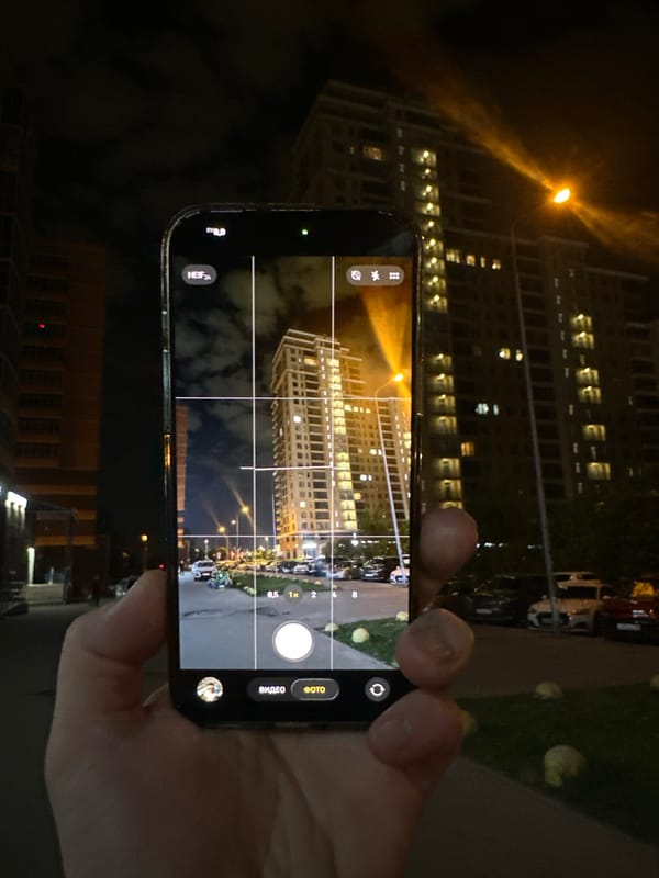 Person photographs apartment building at night in Kazan