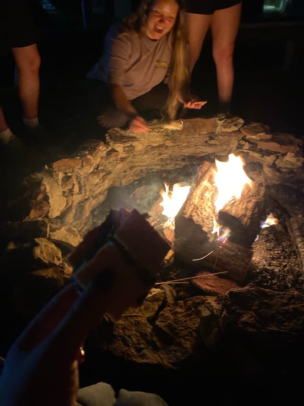 Late-night social gathering features campfire and indoor activities