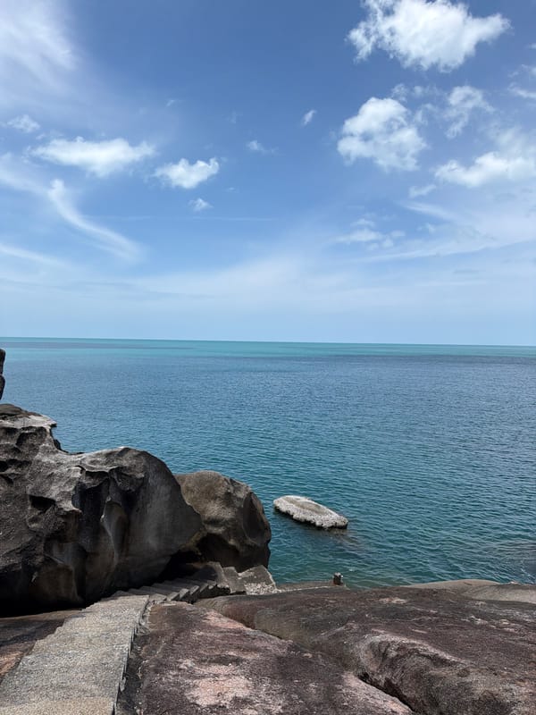 Exploring Ko Samui's boulder-lined coastal road on a clear morning