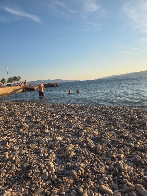 Sunny afternoon at a pebble beach, coast to cityscape