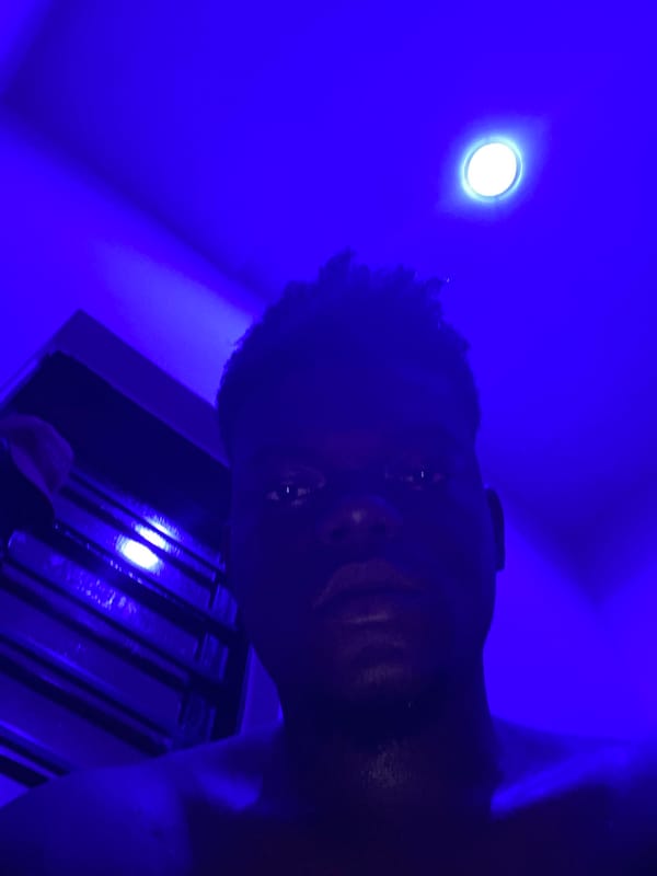Person photographed under blue lighting looking downward