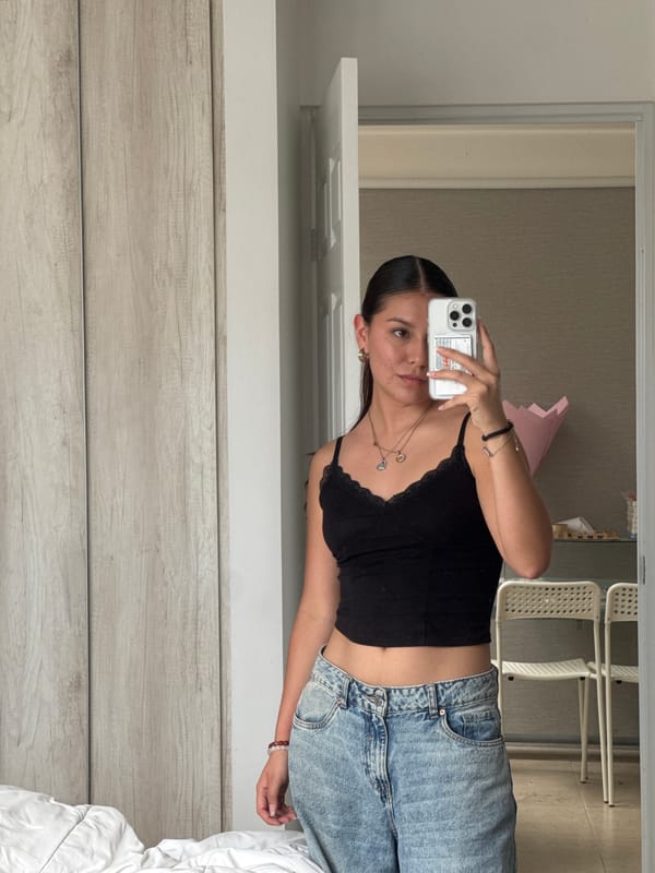 Woman takes mirror selfie in bedroom in Ocotlán