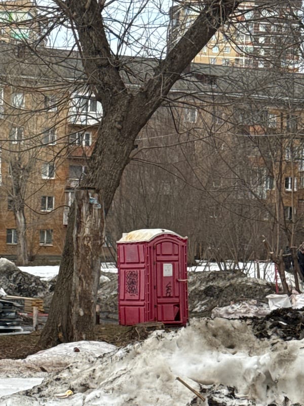 Young women take selfies on Perm street amid winter cityscape