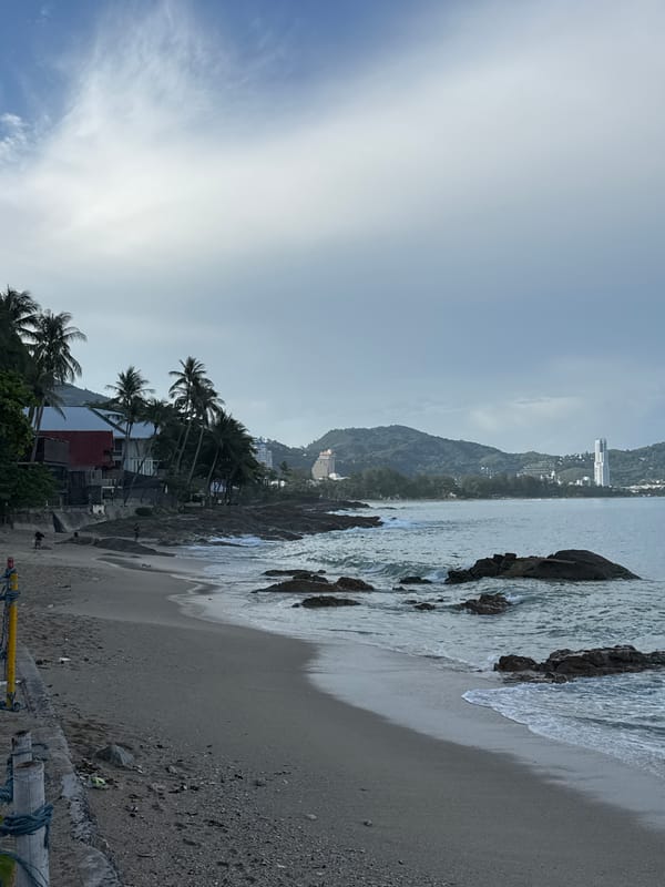 Overcast day at Patong Beach with rocky shores and coastal views