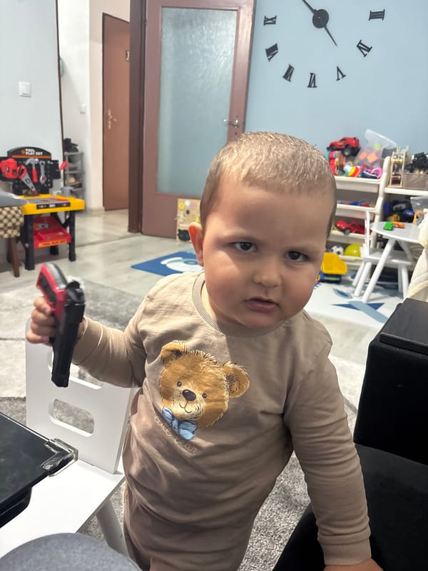 Baby with toy gun photographed in Kazanlak, Bulgaria